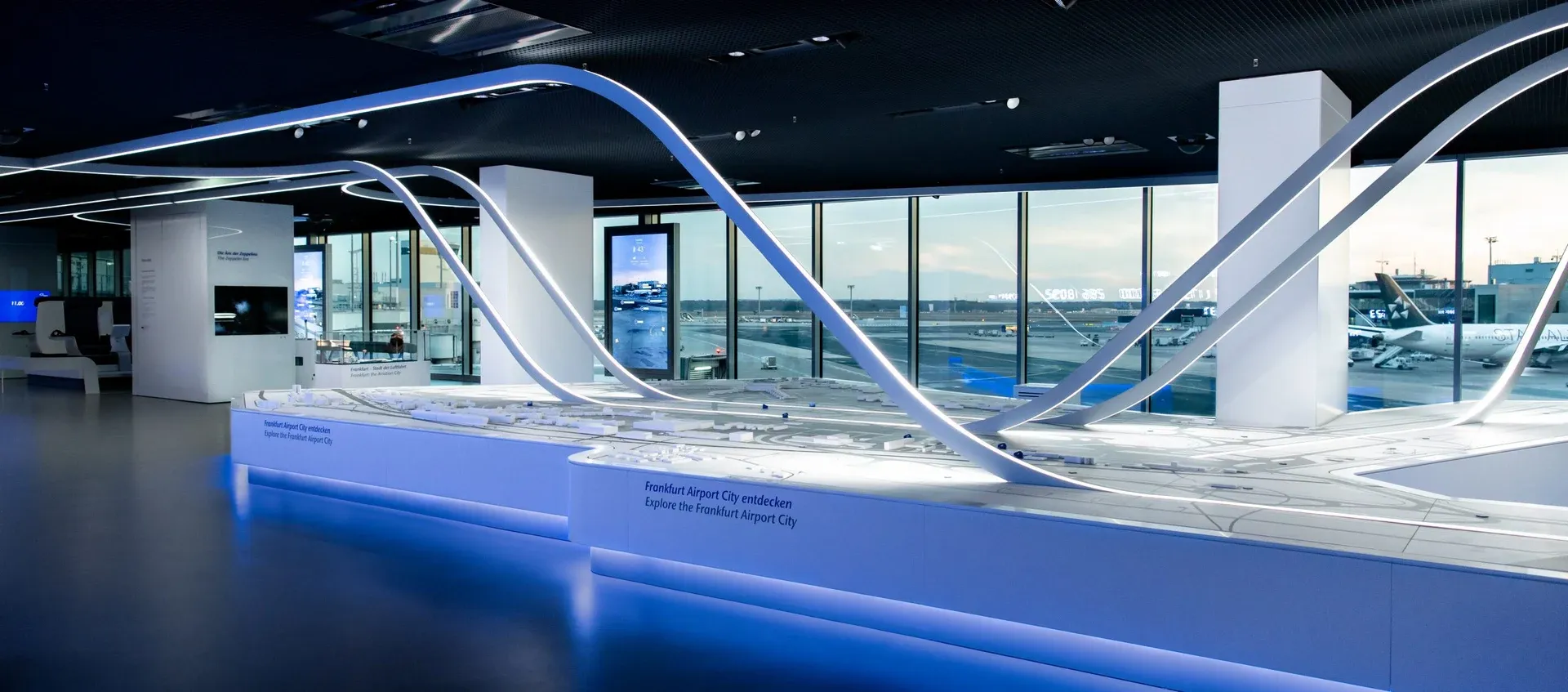 The illuminated Airport City Model and apron-facing exhibition at the Fraport Visitor Center.